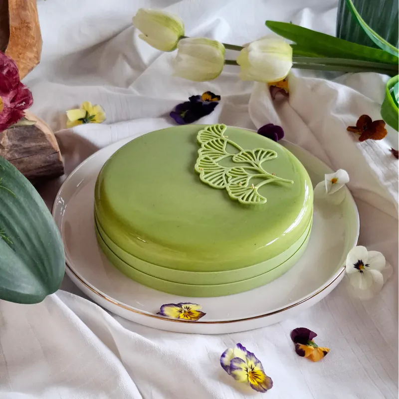 Torta semifreddo Hana, con glassa verde al matcha e decoro a foglie di ginkgo in cioccolato.