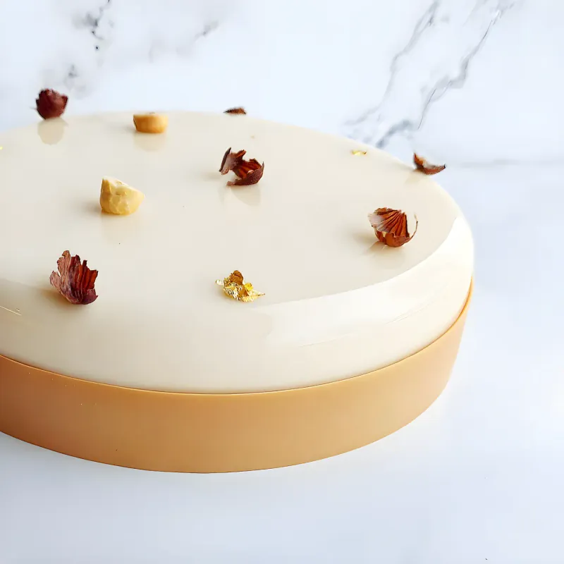 Torta semifreddo La piemontese, con glassa alla vaniglia e nocciole in superficie.